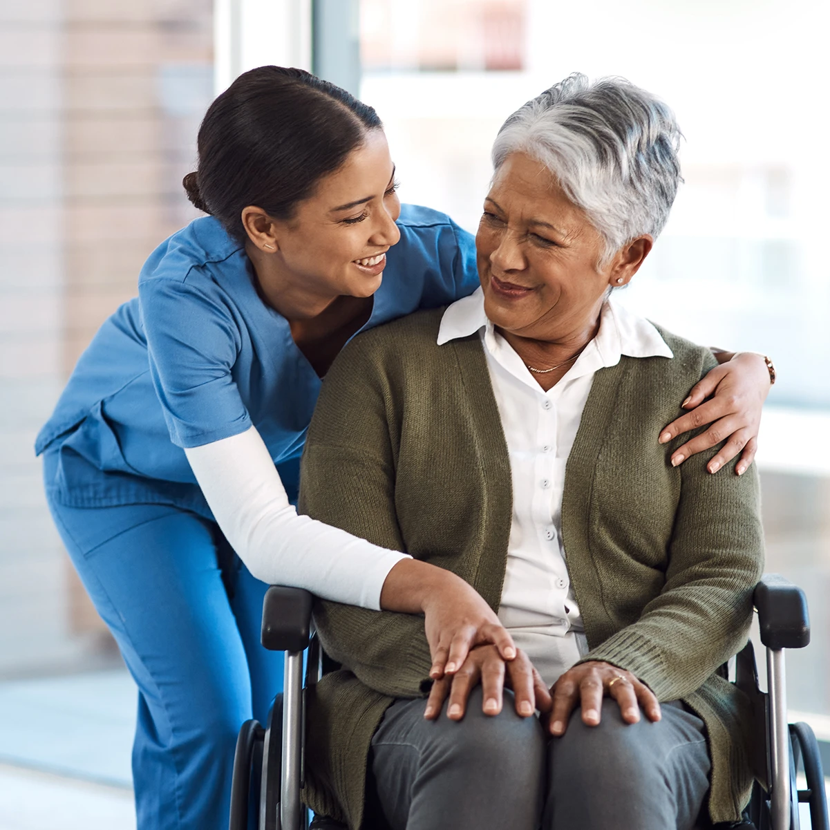 young female nurse with a senior wheelchair-bound patient